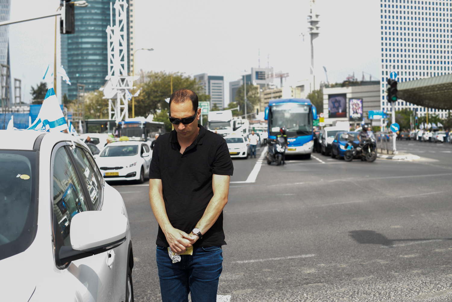 Megemlékezők állnak autójuk mellett a Yom Hashoah napi szirénaszó alatt a Tel Aviv-i Hashalom hidon 2019. május 2-án.