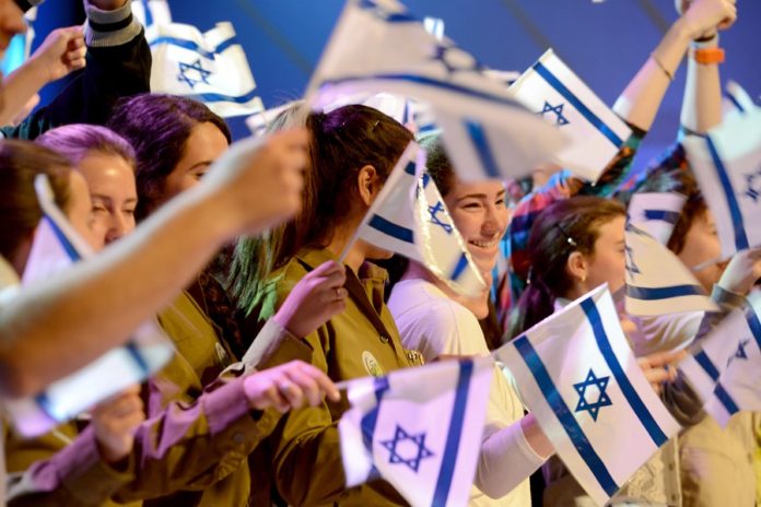 katonalányok izraeli zászlókat lengetnek