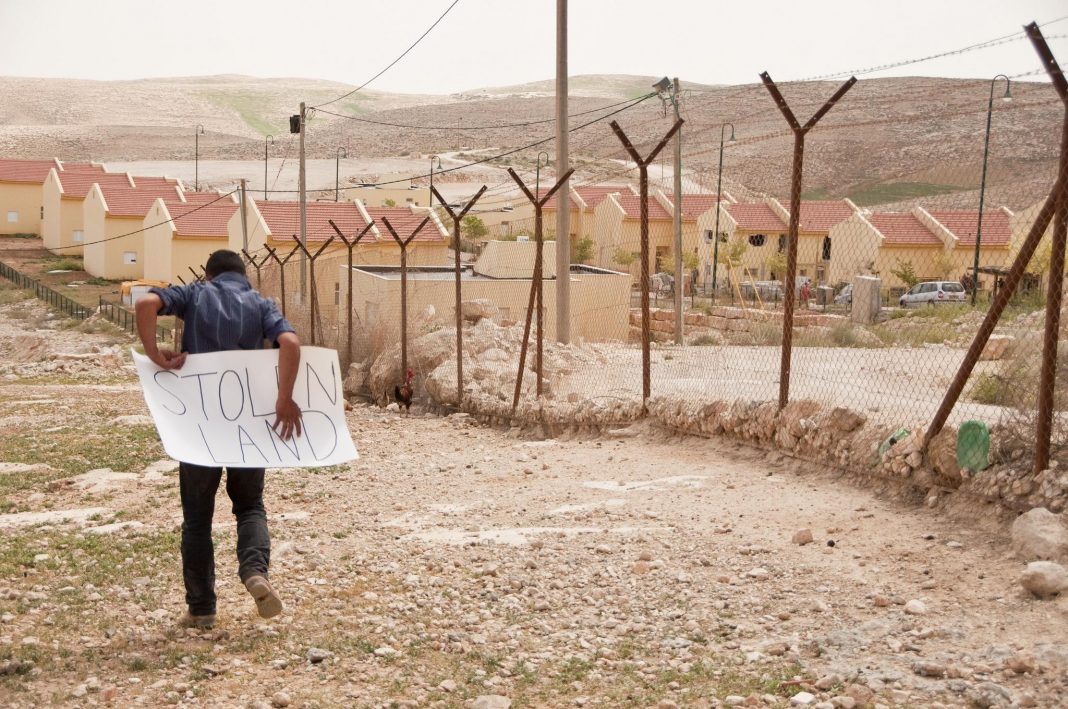 Palesztin fiú egy illegális izraeli település kerítésének túloldalán, Ciszjordániában - fotó: Garry Walsh / Trócaire / Creative Commons