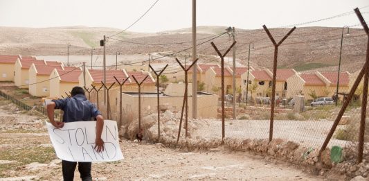 Palesztin fiú egy illegális izraeli település kerítésének túloldalán, Ciszjordániában - fotó: Garry Walsh / Trócaire / Creative Commons