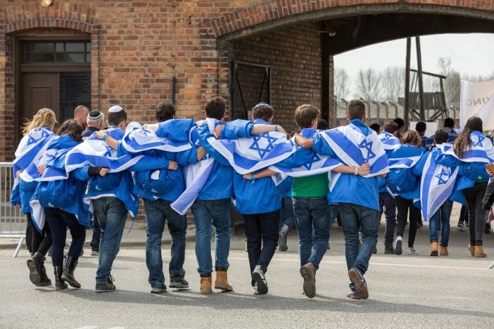 Az Élet Menete résztvevőinek egy csoportja az Auschwitz Birkenau koncentrációs tábor bejáratánál – Fotó: Shutterstock
