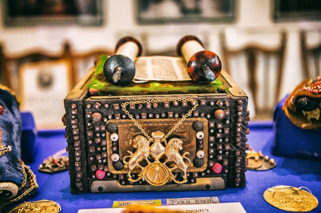 Miniatűr tóratekercs-gyűjtemény hímzett tóraköpenyekkel és díszített állványokkal
